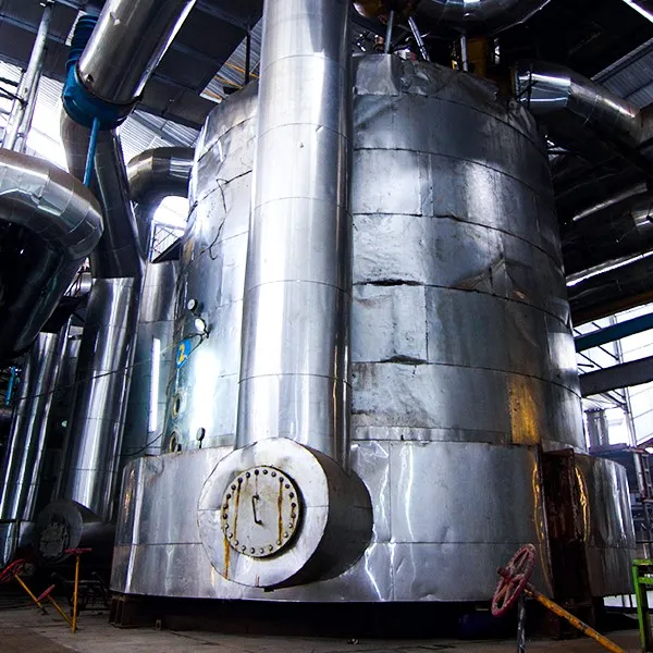 Large stainless steel evaporation vessel with piping, installed as part of a continuous crystallizer system