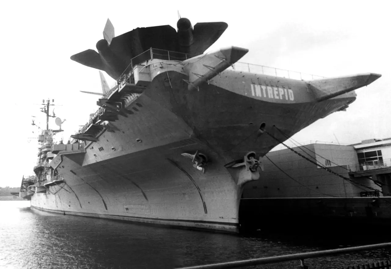 Black and white photograph of the USS Intrepid aircraft carrier, referencing Silver's WWII-era Navy landing barge fabrication history